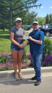Kevin Warren, Executive Director for PAMZ, presents scholarship recipient Kate Finley with a cheque